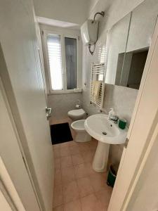 a white bathroom with a toilet and a sink at Home by the sea in Manfredonia