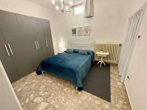 Un dormitorio con una cama azul y una mesa en Home by the sea, en Manfredonia