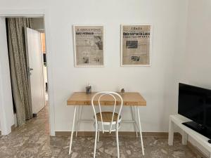einen Tisch mit einem Stuhl und eine Zeitung an der Wand in der Unterkunft Home by the sea in Manfredonia