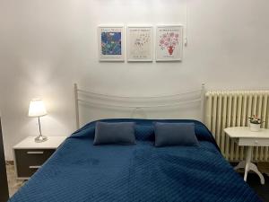 ein Schlafzimmer mit einem blauen Bett mit zwei blauen Kissen in der Unterkunft Home by the sea in Manfredonia