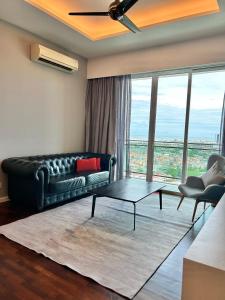 a living room with a couch and a table at LUXURY 3BR Penthouse I The Shore Hotel & Residence I Seaview I Poolview I 6-9Pax in Melaka