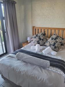 a bedroom with a bed with pillows and a window at 9 on Oostersee in Cape Town