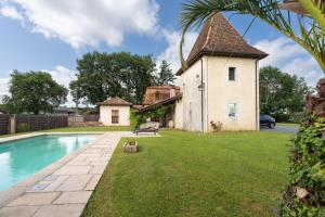 uma vista exterior de uma casa e de uma piscina em Lou Grit - Maison pour 10 avec piscine privée em Salies-de-Béarn