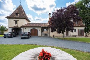 a house with a bunch of flowers in front of it at Lou Grith - Maison pour 10 avec piscine privée in Salies-de-Béarn