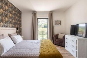 a bedroom with a bed and a flat screen tv at Cottage Douro Vallée 