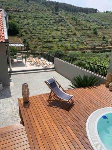 a deck with a chair and a swimming pool at Cottage Douro Vallée 