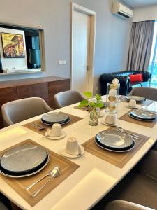 a dining room table with plates and silverware on it at LUXURY 3BR Penthouse I The Shore Hotel & Residence I Seaview I Poolview I 6-9Pax in Melaka