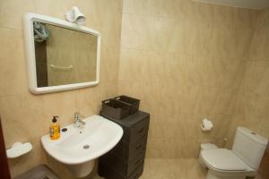 a bathroom with a sink and a toilet and a mirror at El Pommier in Fisterra +21 photos