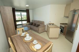 a kitchen and living room with a wooden table and chairs at El Pommier in Fisterra