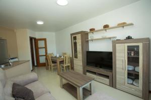 a living room with a couch and a tv and a table at El Pommier in Fisterra