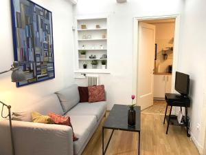 a living room with a couch and a tv at Artistic Deco Apartment in Athens