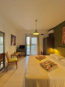 a bedroom with two beds and a living room at Koumaros Aparthotel in Agia Paraskevi