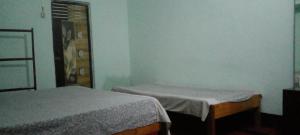 M B Holiday Home في غاواهاتي: غرفة نوم بسريرين في غرفة بها نافذة