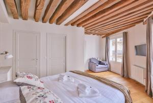 a bedroom with a white bed and a chair at St Michel - Deluxe Apartment - Harpe in Paris