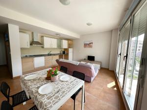 una cucina e un soggiorno con tavolo e divano di Apartamentos Benicarló 3000 a Benicarló