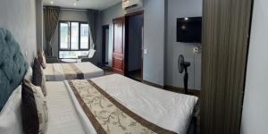 a hotel room with two beds and a television at Khach sạn Vân Nam in Hanoi