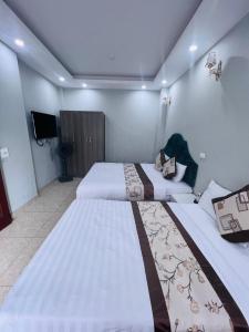 Cette chambre comprend 2 grands lits et une télévision. dans l'établissement Khach sạn Vân Nam, à Hanoï