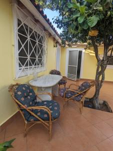 a patio with a table and chairs and a tree at Λευτέρης in Isthmia