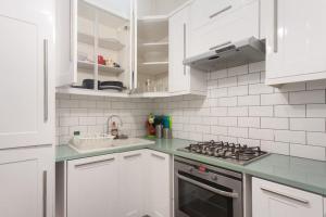 - une cuisine blanche avec cuisinière et placards blancs dans l'établissement Keysan House 1, à Londres