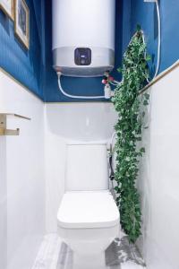 La salle de bains est pourvue de toilettes avec une plante verte. dans l'établissement 24H SELF CHECK In, LARGE APARTMENT WITH 2 BEDROOMS, CLOSE TO BOIS COLOMBES STATION, à Bois-Colombes