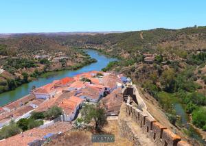 Vue aérienne d'une ville à côté d'une rivière dans l'établissement MyStay - Mértola Castelo Palace, à Mértola
