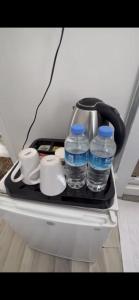 einen Kühlschrank mit zwei Wasserflaschen und Tassen auf einem Tablett in der Unterkunft Heybeliada Pansiyon in Istanbul