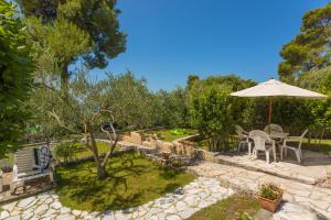 a patio with an umbrella and a table and chairs at La Casita Holiday Home in Petrcane +59 photos