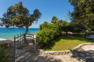 a garden with a fence and the ocean in the background at La Casita Holiday Home in Petrcane