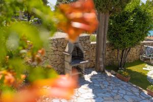 a stone wall with a stone oven in a garden at La Casita Holiday Home in Petrcane