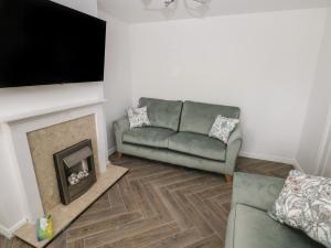 a living room with a couch and a fireplace at 39 Mariners Quay in Port Talbot
