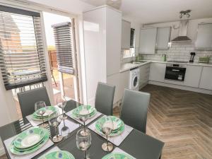 a dining room with a table and chairs in a kitchen at 39 Mariners Quay in Port Talbot