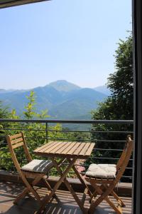 a wooden table and two chairs sitting on a balcony at Ολόκληρο Διαμέρισμα η Βυσσινιά in Kotrónion
