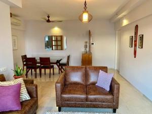 ein Wohnzimmer mit einem Sofa und einem Esszimmer in der Unterkunft Kanakia Paris D wing at BKC, Near Asian Heart Hospital, A Luxury Stay by Connekt Homes in Mumbai