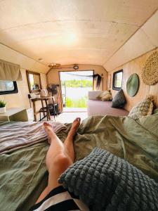 una persona acostada en una cama en una caravana en Wake nams ar pirtiņu en Jēkabpils