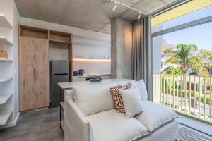 een woonkamer met een bank en een groot raam bij Brand New Seapoint Apartment in Kaapstad