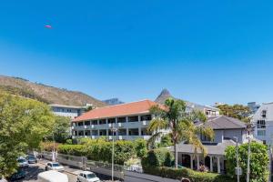 ariaal uitzicht op een gebouw met een palmboom bij Brand New Seapoint Apartment in Kaapstad