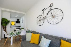 uma sala de estar com um sofá com uma bicicleta pendurada na parede em B11 - Beach Way Apartment em Lagos