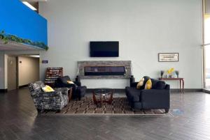 a living room with two couches and a tv at Days Inn by Wyndham Fort Wright Cincinnati Area in Fort Wright