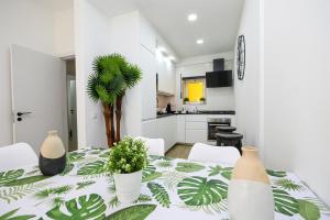 een witte kamer met een tafel met planten erop bij B11 - Beach Way Apartment in Lagos