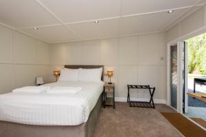 Un dormitorio con una gran cama blanca y una ventana en Millie's Place, en Durham