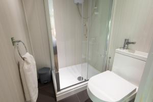 a bathroom with a shower with a toilet and a sink at Millie's Place in Durham