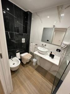 een badkamer met een wastafel, een toilet en een spiegel bij Black & White Luxury Rooms in Bari