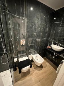 een badkamer met een wastafel, een toilet en een spiegel bij Black & White Luxury Rooms in Bari