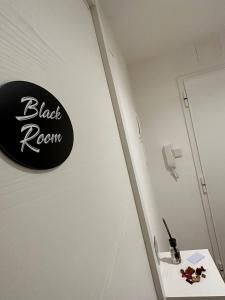 a black room sign on a wall next to a sink at Black & White Rooms in Bari