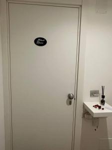a door with a sticker on it next to a sink at Black & White Rooms in Bari
