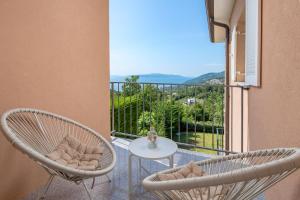 a balcony with two chairs and a table with a view at Villa Oleander Apartman Aria in Poljane