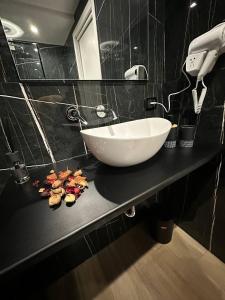 a bathroom with a white bowl sink on a black counter at Black & White Rooms in Bari +50 photos