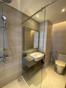 a bathroom with a sink and a toilet and a shower at APEC Mandala Cham Bay Mũi Né Condotel - Vietnam in Phan Thiet