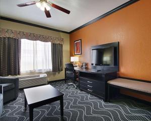Habitación de hotel con cama, escritorio y TV. en Comfort Suites Lake Ray Hubbard, en Rowlett