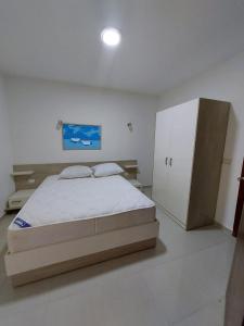 a bedroom with a bed and a white cabinet at Marina Residence New Alamein 2 bedroom apartment in El Alamein